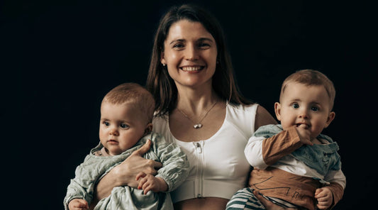 Mother wearing Etalon posture bra while carrying two babies, showing post-pregnancy support.