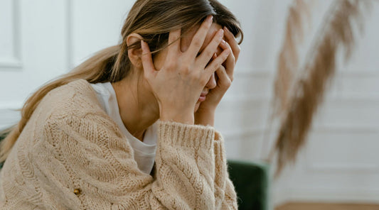 Female experiencing a headache, illustrating connection to poor posture.